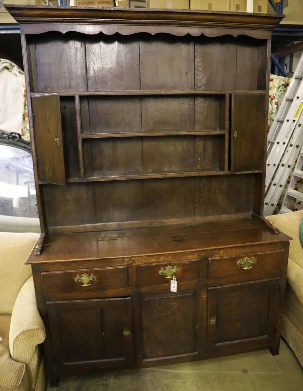A mid-18th century oak dresser having later boarded plate rack over short drawers and panelled doors, width 151cm, depth 43cm, height 2